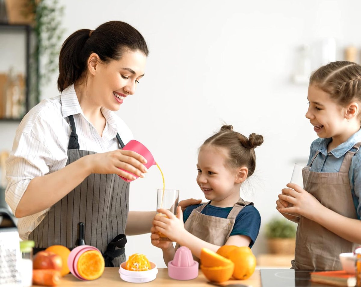 Kids making orange juice with the pink juicer